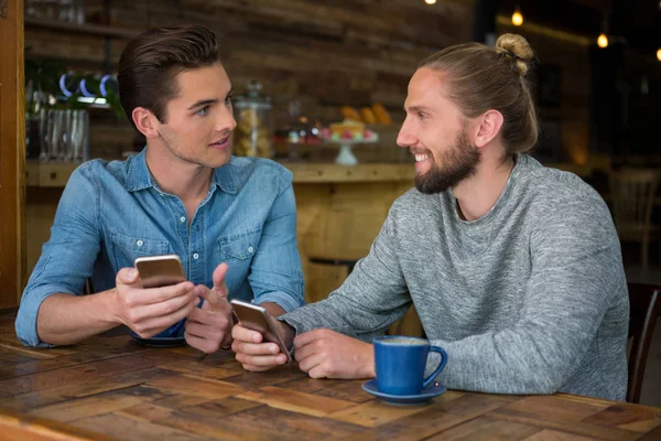 Homme parlant avec un ami à table — Photo