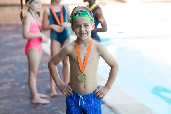 Felice ragazzino indossando medaglia a bordo piscina — Foto Stock