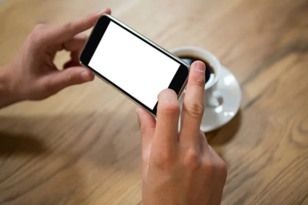 Чоловік руками фотографує каву через смартфон в кафе — стокове фото