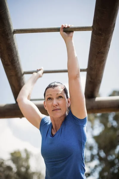 Fitte Frau klettert auf Affenstangen — Stockfoto