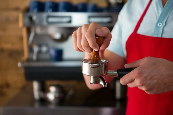 Barista verwendet Stampfer, um gemahlenen Kaffee zu pressen — Stockfoto