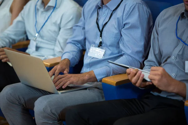 Bedrijfsleiders die deelnemen aan een zakelijke bijeenkomst met behulp van elektronische apparaten — Stockfoto