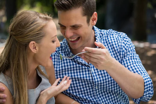 Sorrindo homem alimentando mulher no restaurante ao ar livre — Fotografia de Stock