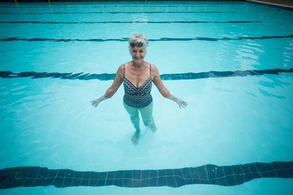 Heureuse femme âgée nageant dans la piscine — Photo