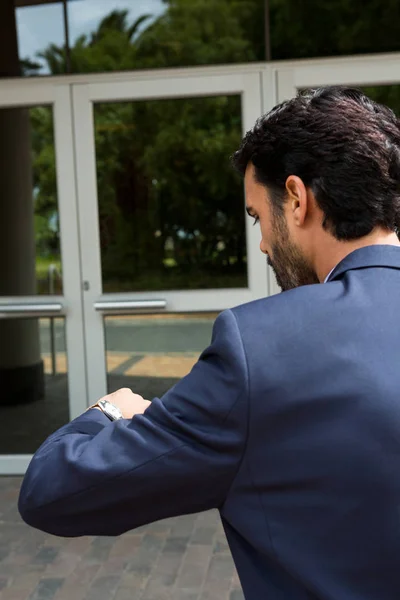 Businessman checking time while walking — Stock Photo, Image