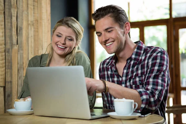 Fröhliches Paar mit Laptop am Tisch — Stockfoto