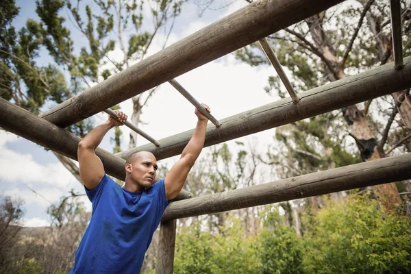 Ajuste hombre escalando barras de mono — Foto de Stock