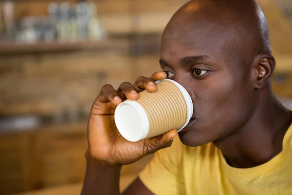 Jonge man drinkt koffie in Cafe — Stockfoto