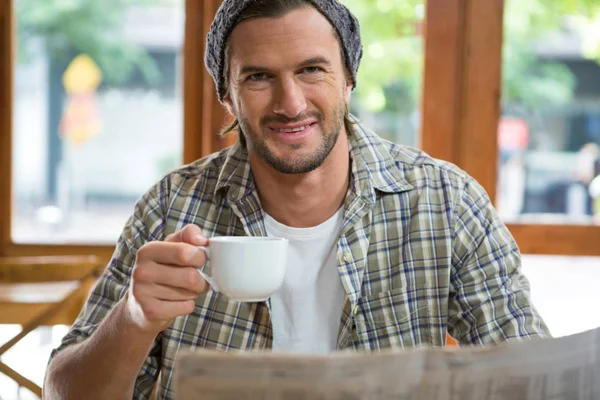 Retrato de homem sorridente segurando xícara de café no café — Fotografia de Stock