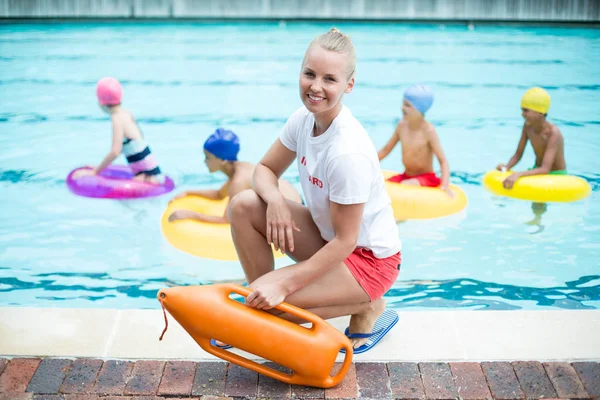 Kvinnlig livräddare innehav räddning kan vid poolen — Stockfoto