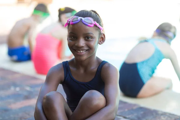 Felice bambina seduta a bordo piscina — Foto Stock