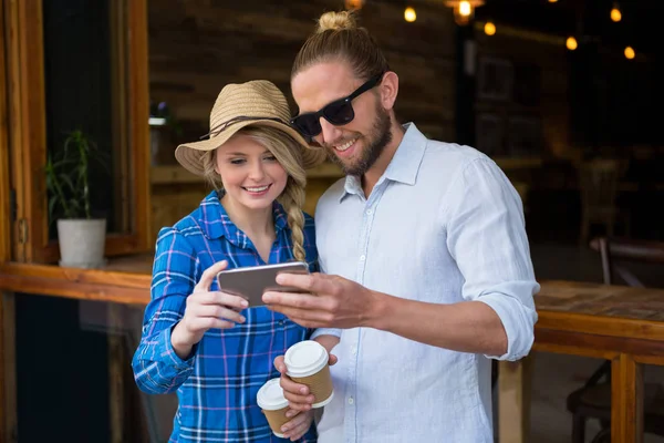 Пара с помощью смартфона в кафе — стоковое фото