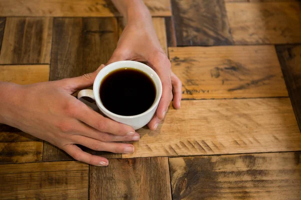Man met koffiekopje aan tafel in café — Stockfoto