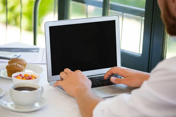 Empresário usando laptop à mesa no restaurante — Fotografia de Stock