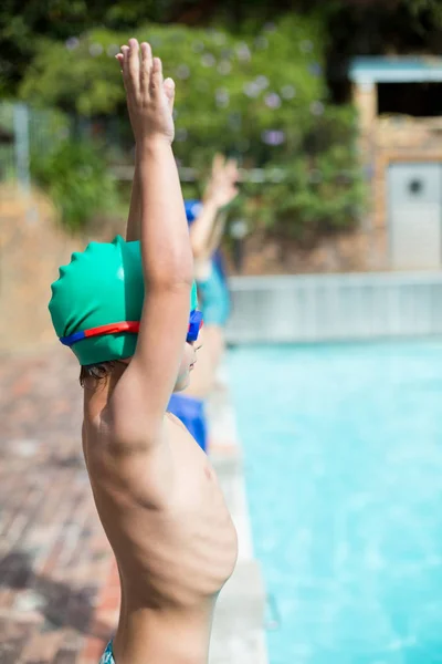 Braços levantados menino em pé à beira da piscina — Fotografia de Stock