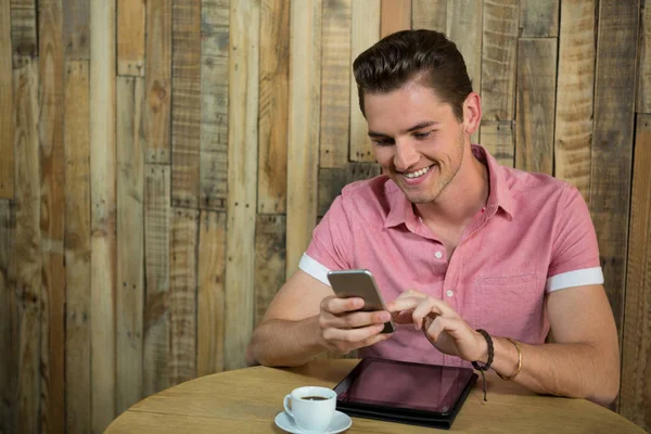 Homem usando telefone inteligente na mesa — Fotografia de Stock