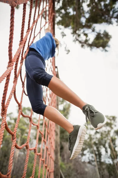 Vrouw net klimmen tijdens hindernissenparcours — Stockfoto