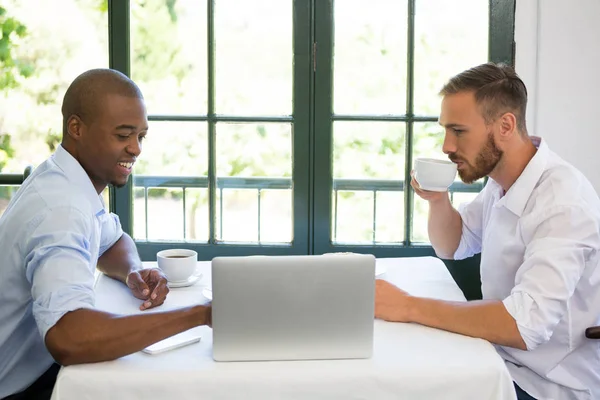 Gente de negocios discutiendo sobre portátil en restaurante — Foto de Stock