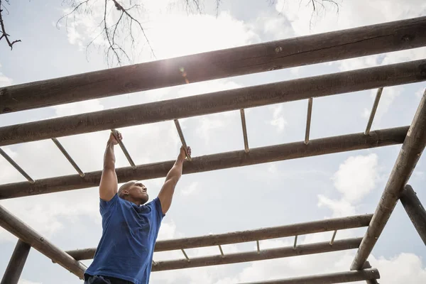 Ajuste hombre escalando barras de mono — Foto de Stock