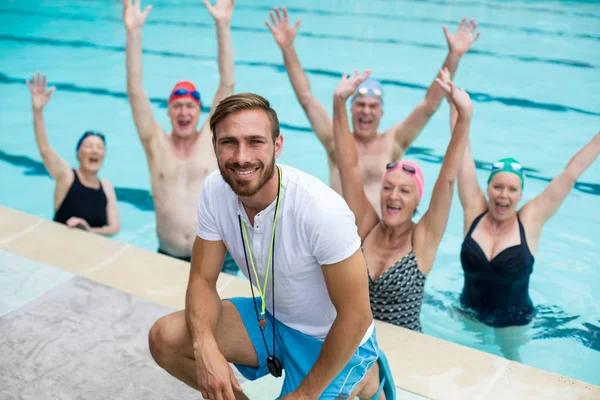 Instructor con nadadores senior despreocupados en la piscina — Foto de Stock