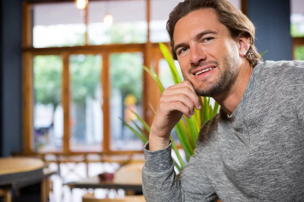 Confident young man in coffee shop