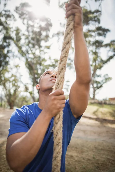 Fit mens touw klimmen tijdens hindernissenparcours — Stockfoto