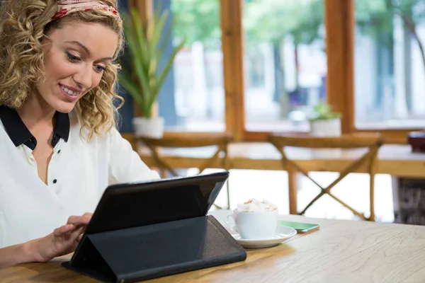 Όμορφη γυναίκα χρησιμοποιώντας ψηφιακό tablet στο τραπέζι στην καφετέρια — Φωτογραφία Αρχείου