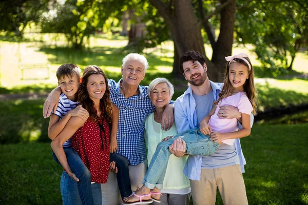 Famille souriante posant ensemble dans le parc — Photo