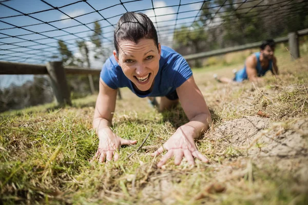 Fit woman crawling under the net — Stock Photo, Image