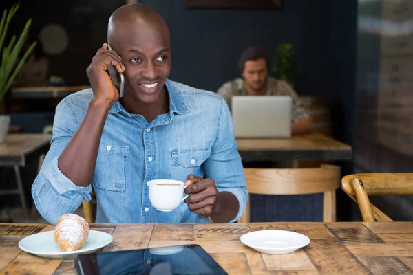 Uomo che parla al telefono mentre prende un caffè — Foto Stock