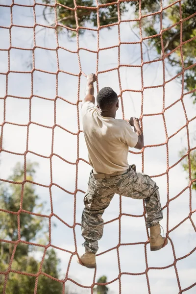 Soldado militar escalando red — Foto de Stock