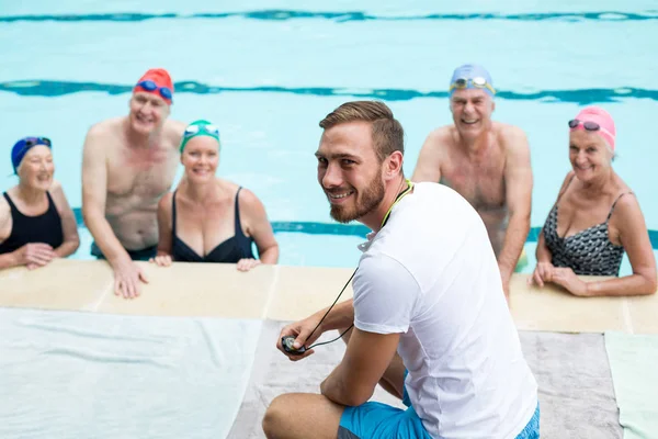 Manlig instruktör bistå senior simmare — Stockfoto