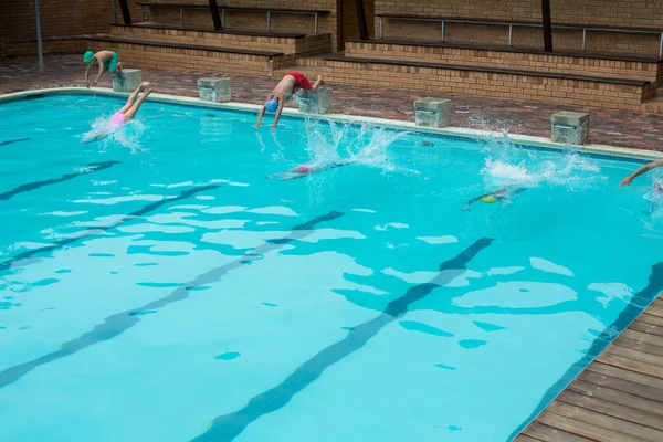 Schwimmer springen ins Becken — Stockfoto