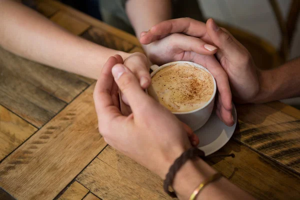 手とカフェテリアでコーヒー カップを保持しているカップル — ストック写真