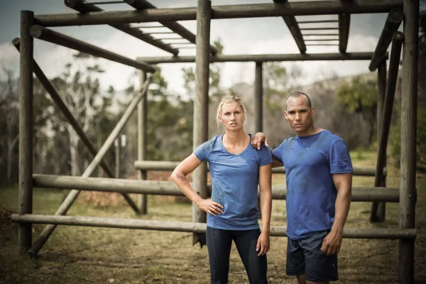 Fit vrouw en man tegen monkey bars — Stockfoto