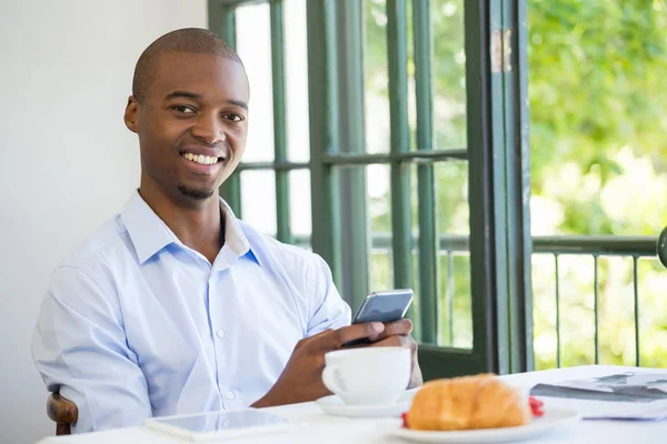 Lachende zakenman houden van mobiele telefoon in restaurant — Stockfoto