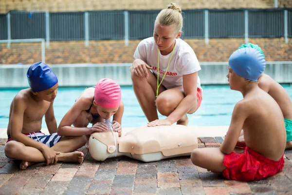 Lifeguard att hjälpa barn under räddning utbildning — Stockfoto