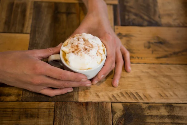 Homem mãos segurando xícara de café na mesa — Fotografia de Stock