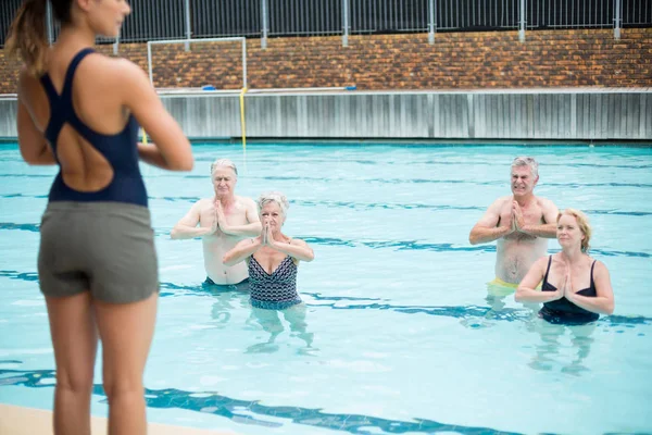 Yoga trainer bistå senior simmare — Stockfoto