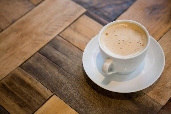 Šálek kávy na dřevěný stůl v jídelně — Stock fotografie