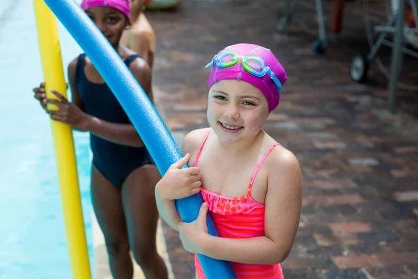 Små flickor med pool nudlar vid poolen — Stockfoto