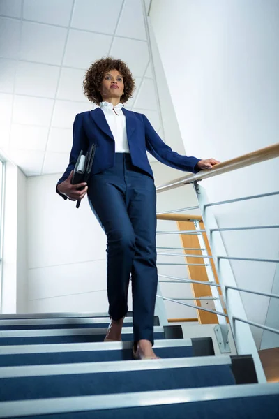 Businesswoman with diary climbing down the stairs — Stock Photo, Image