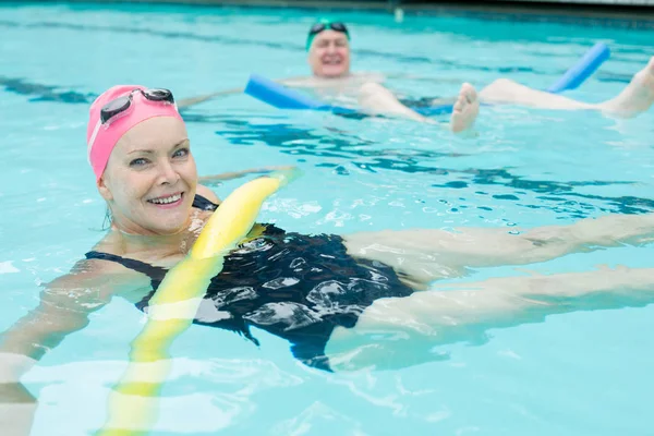 Äldre par simma med pool nudlar — Stockfoto