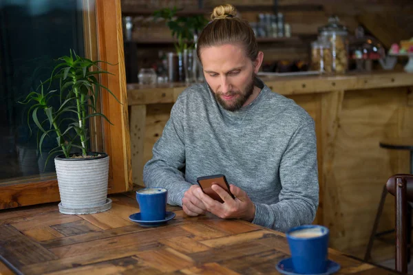 Mężczyzna hipster przy użyciu telefonu komórkowego w tabeli — Zdjęcie stockowe