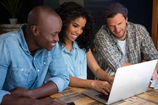 Amici che utilizzano il computer portatile in caffetteria — Foto Stock