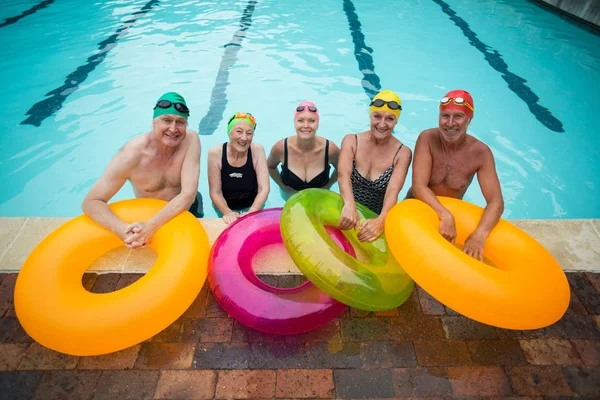 Senior simmare med uppblåsbara ringar står vid poolkanten — Stockfoto