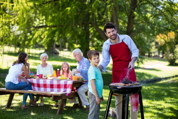 Отец и сын готовят барбекю в парке — стоковое фото