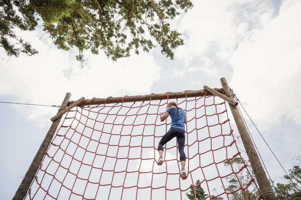 Fit vrouw klimmen naar beneden van het net — Stockfoto