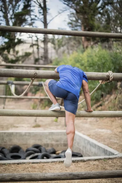 Man overschrijding van het touw tijdens hindernissenparcours — Stockfoto