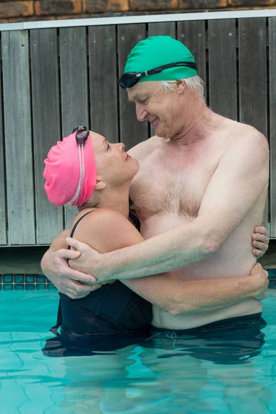Ouder paar kijken elkaar in zwembad — Stockfoto
